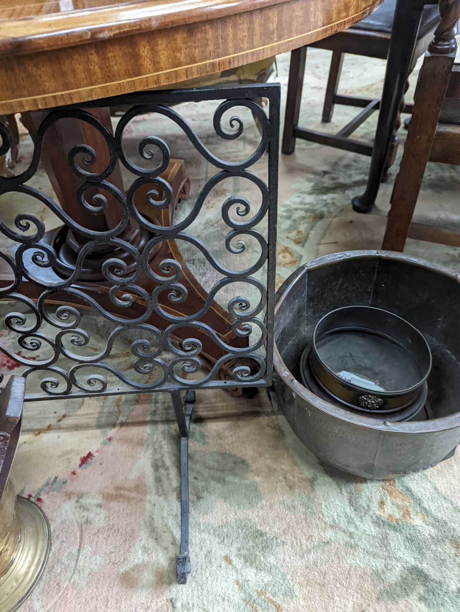 A wrought iron scroll work firescreen, width 95cm, a Dutch embossed brass scuttle, two trivets, coal bin and assorted metalware